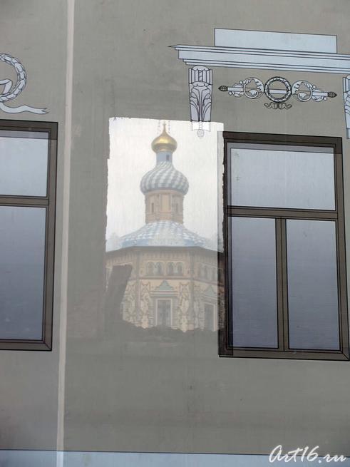 В проеме окна, сквозь банерную ткань виден Петропавловский собор