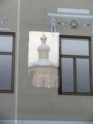 В проеме окна, сквозь банерную ткань виден Петропавловский собор