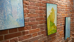Картины, украшающие стену вдоль лестницы в Музее-галерее «Дом-арт»