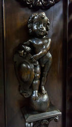 Фигурка ребенка, держащего герб
